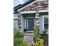 Stylish front entry showcases a textured brick surround with a gray front door at 12351 Nouveau Ave, Spring Hill, FL 34610