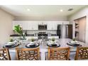 Beautiful kitchen island with stainless steel appliances and four bar stool chairs at 13050 Wellspring Dr, Lithia, FL 33547