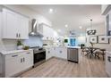 Modern, open-concept kitchen with white cabinets, stainless steel appliances, and stylish dining area at 13203 Royal George Ave, Odessa, FL 33556