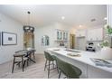 Stylish kitchen with island, modern pendant lighting, and adjacent dining area for entertaining at 13203 Royal George Ave, Odessa, FL 33556