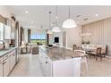 Modern kitchen boasts a large island, white cabinets, stainless steel appliances and an adjacent dining nook at 13644 Canyon Ridge Rd, Spring Hill, FL 34610