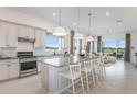 Bright and airy kitchen features an island with seating, white cabinets, and a view of the living area at 13644 Canyon Ridge Rd, Spring Hill, FL 34610