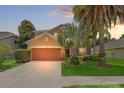 Two-story home with a two-car garage, well-maintained landscaping and palm trees at 13830 Trull Way, Hudson, FL 34669