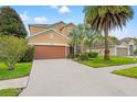 Two-story home with a two-car garage, well-maintained landscaping and palm trees at 13830 Trull Way, Hudson, FL 34669