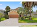 Two-story home with a two-car garage, well-maintained landscaping and palm trees at 13830 Trull Way, Hudson, FL 34669