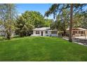 Inviting home featuring lush green lawn, mature trees, and charming curb appeal, perfect for outdoor enjoyment at 1512 Hillside Dr, Tampa, FL 33610