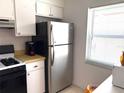 Cozy kitchen featuring stainless steel refrigerator and plenty of counter space, bathed in natural light at 1605 Mission Hills Blvd # D5, Clearwater, FL 33759