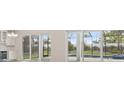 View of the backyard featuring a screened-in pool area, landscaping, and a view of the home's interior at 17555 Glistening Ct, Venice, FL 34293