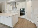 Modern kitchen with white cabinets, stainless steel appliances and a center island with white countertop at 17555 Glistening Ct, Venice, FL 34293
