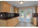 Bright kitchen with wooden cabinets, dark countertops, and access to the backyard through glass doors at 1949 Kings Hwy, Clearwater, FL 33755