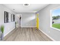 Modern living room features hardwood floors, updated lighting, and a bright yellow door at 201 83Rd N Ave, St Petersburg, FL 33702