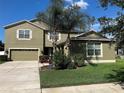 Well-maintained two-story home with lush lawn, mature trees, desert landscaping, and a two-car garage plus a one-car garage at 20101 Oakflower Ave, Tampa, FL 33647