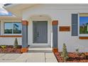 Close-up of the front entrance with a stylish gray door and modern architectural details at 20390 Lorenzo Ave, Port Charlotte, FL 33952