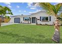Beautiful single-story home with a well-manicured lawn and palm tree at 20390 Lorenzo Ave, Port Charlotte, FL 33952