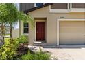 The property features a brick walkway, a red front door, and manicured landscaping at 22359 Storybook Cabin Way, Land O Lakes, FL 34637
