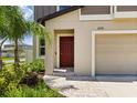 The property features a brick walkway, a red front door, and manicured landscaping at 22359 Storybook Cabin Way, Land O Lakes, FL 34637