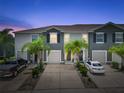 Beautiful townhomes, framed by palm trees, featuring well-kept driveways and inviting exteriors at twilight at 2699 Suncoast Blend Dr, Odessa, FL 33556