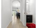 Bright hallway with tiled floors leads to a dining area and powder room with a modern vanity at 2699 Suncoast Blend Dr, Odessa, FL 33556
