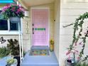 Close-up of front entrance with pastel door, colorful welcome mat, and decorative plants at 2707 56Th S St, Gulfport, FL 33707