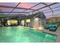 Relaxing screened pool area with comfortable seating, covered patio, and views of the home's exterior at 3113 Chamblee Ln, Clearwater, FL 33759