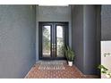 Elegant double front door with decorative glass panels and brick entryway at 3241 Evening Breeze Loop, Wesley Chapel, FL 33544