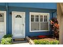 Close up of the townhome entrance featuring a white door, storm door, and a decorative window at 3323 Fox Hunt Dr, Palm Harbor, FL 34683