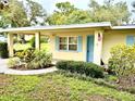 Charming single-story home with inviting covered entrance and vibrant landscaping surrounding the entryway at 3575 Lake Highland Dr, Palm Harbor, FL 34683