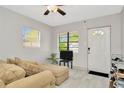 Cozy living room features neutral paint, ceiling fan, light tile floors and lots of natural light at 3714 N Garrison St, Tampa, FL 33619