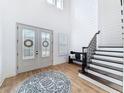 Bright and open foyer featuring hardwood floors, a staircase, shiplap accent wall, and double glass doors at 4080 Bonfire Dr, Odessa, FL 33556