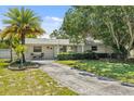 Attractive single-story home featuring mature landscaping, a well-maintained lawn, and a cozy front patio at 4530 Catalonia S Way, St Petersburg, FL 33712