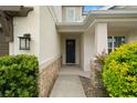 Inviting front entrance with a dark blue door, stone accents, and manicured landscaping at 4607 Los Robles Ct, Palmetto, FL 34221