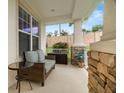 Covered patio with cozy seating area, brick accents, and view of the landscaped yard at 4607 Los Robles Ct, Palmetto, FL 34221