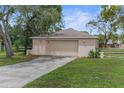 Detached two-car garage with a concrete driveway and green lawn in a serene setting at 5112 Odin St, Spring Hill, FL 34608