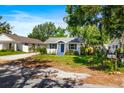 Charming single-story home with a blue front door, white siding, and a well-kept lawn at 716 35Th W St, Bradenton, FL 34205