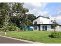 Modern two-story home with black trim, complimented by a well-maintained lawn and mature trees at 8274 Rose Ter, Seminole, FL 33777