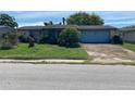 Charming single-story home with a front lawn and an attached garage at 9510 Mark Twain Ln, Port Richey, FL 34668