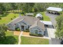 Aerial view of the charming single-story home with a well-kept lawn and ample parking at 23268 Family Ln, Brooksville, FL 34602
