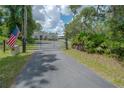Gated driveway with an American flag, providing privacy and security at 23268 Family Ln, Brooksville, FL 34602