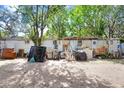 This exterior shot displays the yard of a vintage mobile home, under trees and shadows at 10044 Oana St, New Port Richey, FL 34654