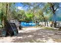 This exterior view features a large yard, mature trees, and a vintage home at 10044 Oana St, New Port Richey, FL 34654