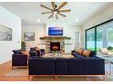 Cozy living room features a stone fireplace, a ceiling fan, and sliding doors to the outdoor patio at 1015 W Charter St, Tampa, FL 33602