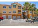 Exterior of condo building featuring assigned parking and garages with balconies and tropical landscaping at 10764 70Th Ave # 4305, Seminole, FL 33772