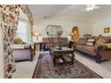 Cozy living room with stylish furniture, ceiling fan, and archway to the dining room, all on tile flooring at 11251 Pickford St, Spring Hill, FL 34609