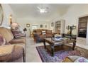 Relaxing living room with vaulted ceiling, a ceiling fan, tile flooring, and a large window for natural light at 11251 Pickford St, Spring Hill, FL 34609