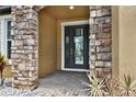 Elegant stone archway frames the front door, enhancing the entryway's appeal at 11613 Sweet Tangerine Ln, Tampa, FL 33626