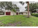Inviting single-story home with lush lawn, dark garage door, and arched front entryway at 13344 88Th Ave, Seminole, FL 33776