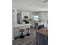 Bright kitchen features white cabinets, stainless steel appliances, quartz countertops, and a breakfast bar with seating at 13344 88Th Ave, Seminole, FL 33776