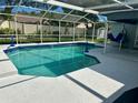 Inviting screened-in pool area with clear blue water, a surrounding patio, and a glimpse of the backyard at 15101 Bald Eagle St, Tampa, FL 33625