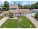 Aerial view of a two-story home featuring a manicured lawn, attached garage, and a covered carport at 1712 Azalea Ct # B, Oldsmar, FL 34677