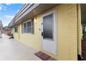 Street view of condo with neutral tones and a storm door that allows ample light at 201 Bedford St # 79, Sun City Center, FL 33573
